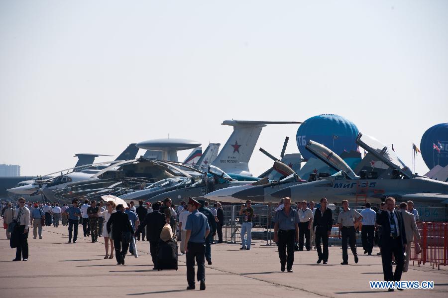 Visitors walk past the airplanes on the Tenth Russia National Aerospace Exhibition in Moscow, Russia on Aug. 16, 2011. The Exhibition will last for six days, and 793 companies from 40 nations and regions participated. [Jiang Kehong/Xinhua] 