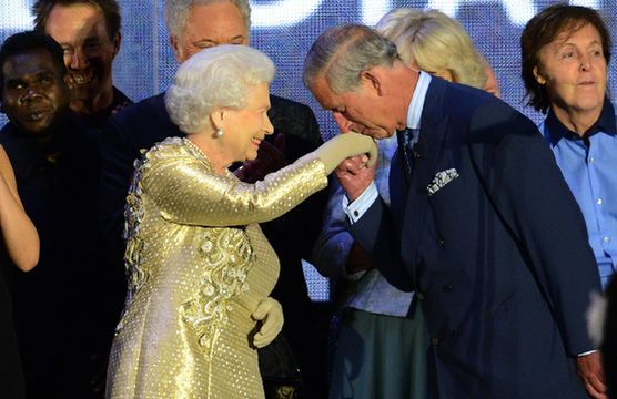 Prince Charles kisses the hand of Britain's Queen Elizabeth II on stage as well as British singer Paul McCartney (R) looks on after the Jubilee concert at Buckingham Palace. in London, on June 4, 20112. [Xinhua] 